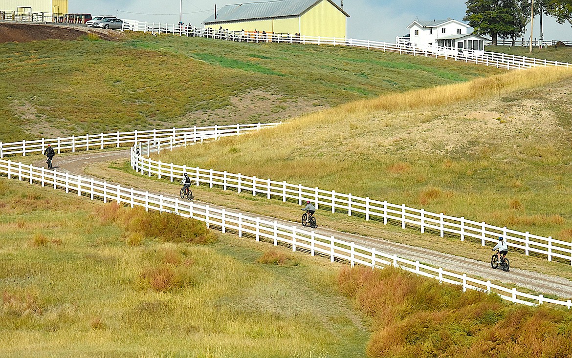 Bikers pedal up the hill at the Westphal Charolais Ranch west of Ronan during the Mission Mountain Area Pedal to Plate event. When the cyclists reached the top of the hill, they were rewarded with a snack of hard-boiled eggs from Mission Mountain Organic eggs. (Berl Tiskus/Leader)