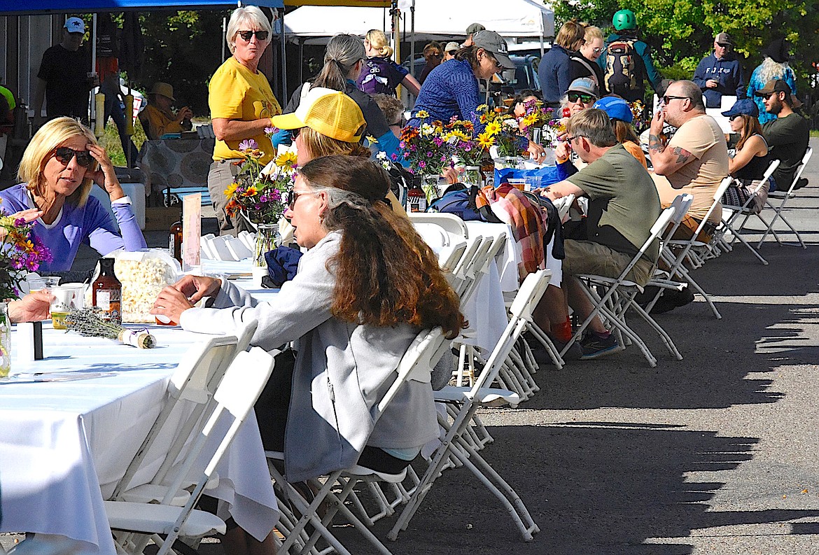 Cyclists relax after the MMAPP ride on Saturday, enjoying a Flare Pop or a cold beer from the Ronan Cooperative Brewery as they wait for dinner. (Berl Tiskus/Leader)