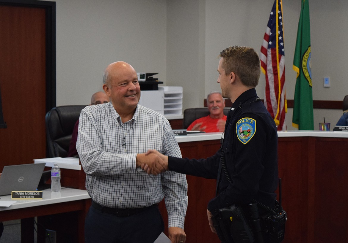 Newly sworn-in Othello Police Officer Brock Denney shakes Mayor Shawn Logan’s hand at the Othello City Council meeting Monday evening.