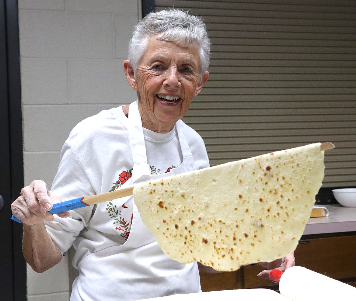 Beverly Knutson smiles as she displays lefse hot off the grill on Wednesday.