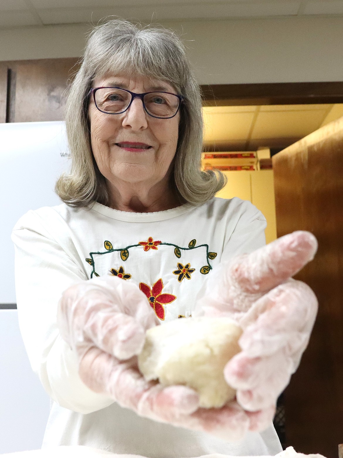 Pam Hunt turns dough for lefse into smaller portions so they can be rolled flat in the next step of the process at Trinity Lutheran Church on Wednesday.