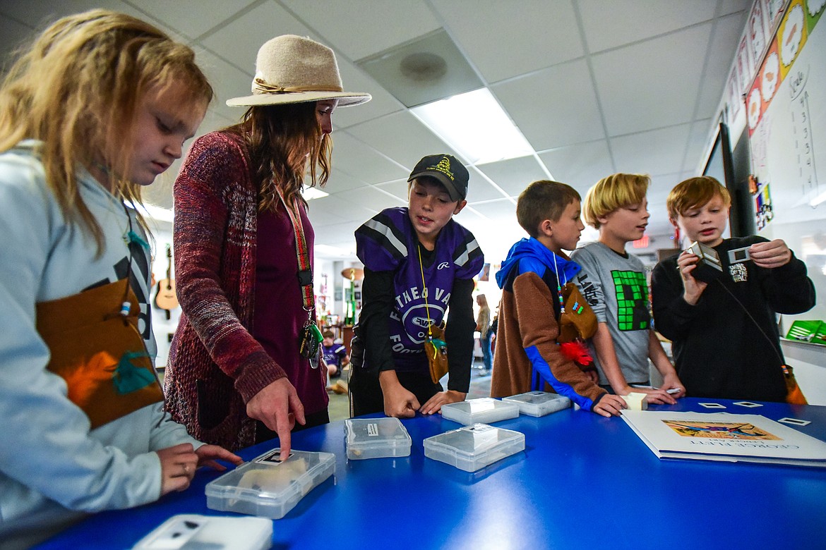 Students are shown Native American artifacts and view images on a slide viewer at a touch and feel exhibit during Kila School's Native American Heritage Day in Kila on Friday, Sept. 29. (Casey Kreider/Daily Inter Lake)
