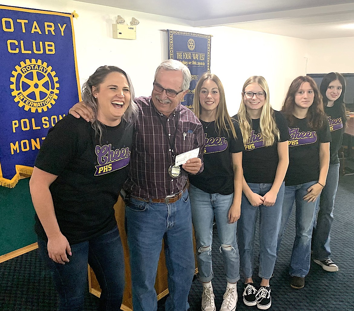 Polson High School cheerleading coach Alysha Valentine receives a check for $250 from her dad, Rotary president Dennis Duty, during last week's presentation of proceeds from Rotary's annual BrewFest.