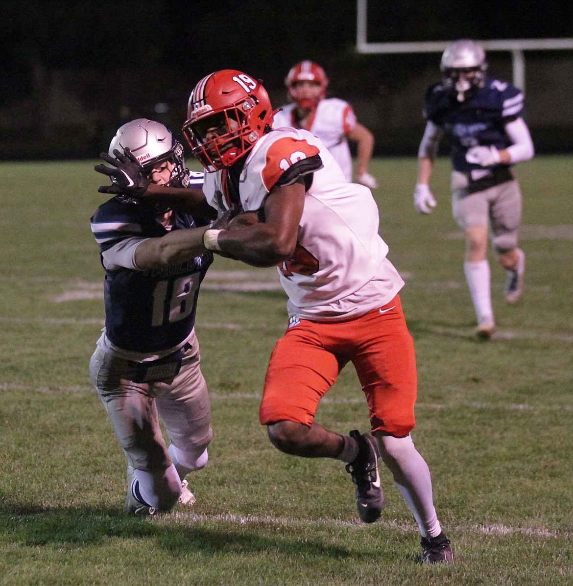 Eli Allshouse of Sandpoint races toward the end zone as Jacob Hill of Lake City tries to tackle him after Allshouse stripped the ball from the Lake City receiver, and ran it in for a touchdown in the third quarter Friday night at Lake City.