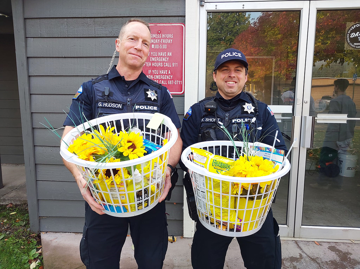 Officers Greg Hudson and Ken Short accept baskets of sunshine from the Mountain View Alternative High School seniors Friday.