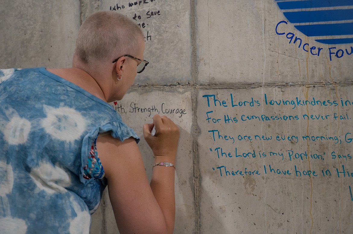 A cancer patient adds a message of encouragement to the walls of the Radiation Oncology Center as part of the Written in Stone project during construction in summer 2023. The facility will be unveiled at an open house Saturday.