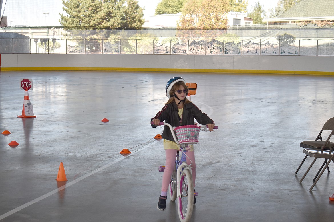 Eight-year-old Kira Close rides triumphantly off the advanced obstacle course set up on the hockey rink at the Larson Recreation Center in Moses Lake Saturday.