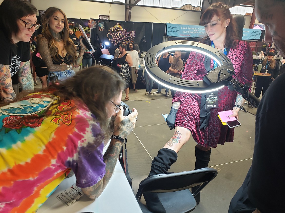 Owner of the Northwest Tattoo Museum Jay Brown photographs Jess McNabb's tattoo during a competition at the Gem State Tattoo Convention on Sunday.