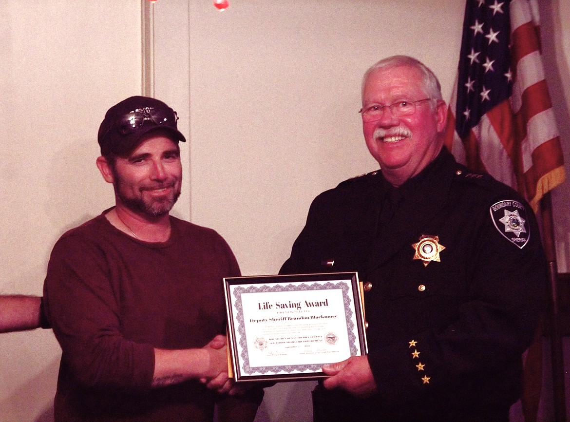 Boundary County Sheriff's Office Deputy Branden Blackmore (left) receives a Life Savings Award from Sheriff Kramer.