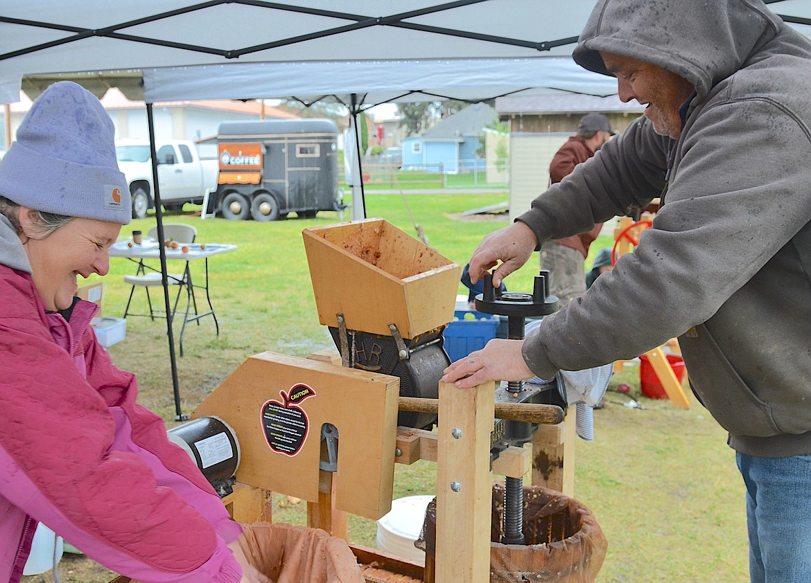 Emily and Brett Peterson press cider for an upcoming event at their Kunekune Ranch in Round Butte. Both apples and cider presses were available during CSKT's annual Fall Wildlife Festival, held Saturday at the Ronan Visitor's Center. (Kristi Niemeyer/Leader)