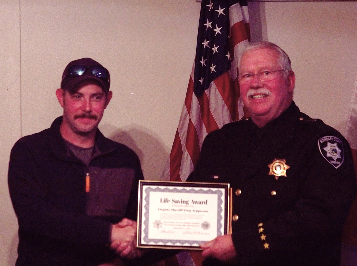 Boundary County Sheriff's Office Deputy Anthony Jeppesen (left) receives his Life Saving Award from Sheriff Kramer.