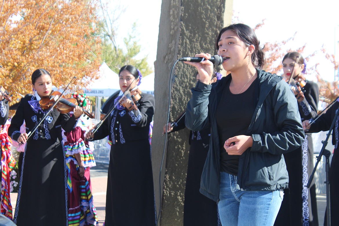 Mariachi Huenachi alumna Anyanna Ramirez, with microphone, was called up on stage to sing a ballad during the group’s performance.
