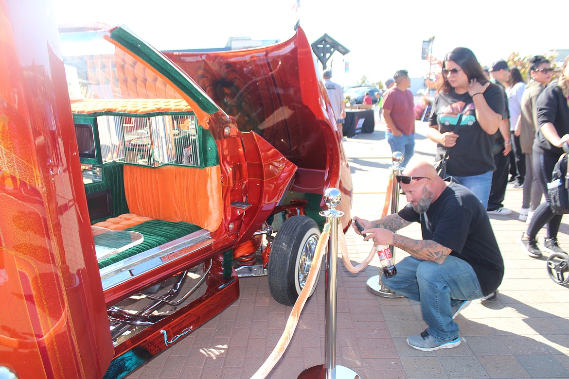 A spectator snaps a picture of some of the details of a showstopping car at the UMANI Festival.
