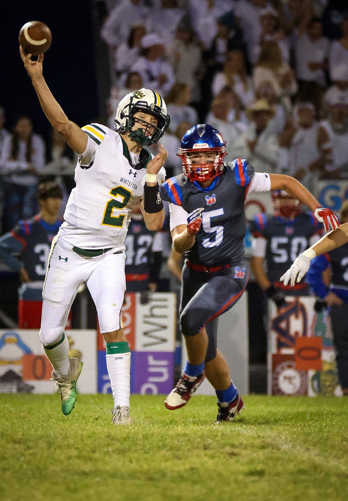 Quarterback Carson Gulick evades Vikings defender Eli Thorness to complete a pass in the fourth quarter of Whitefish's 20-16 win at Bigfork Friday. (Jeremy Weber/Bigfork Eagle)