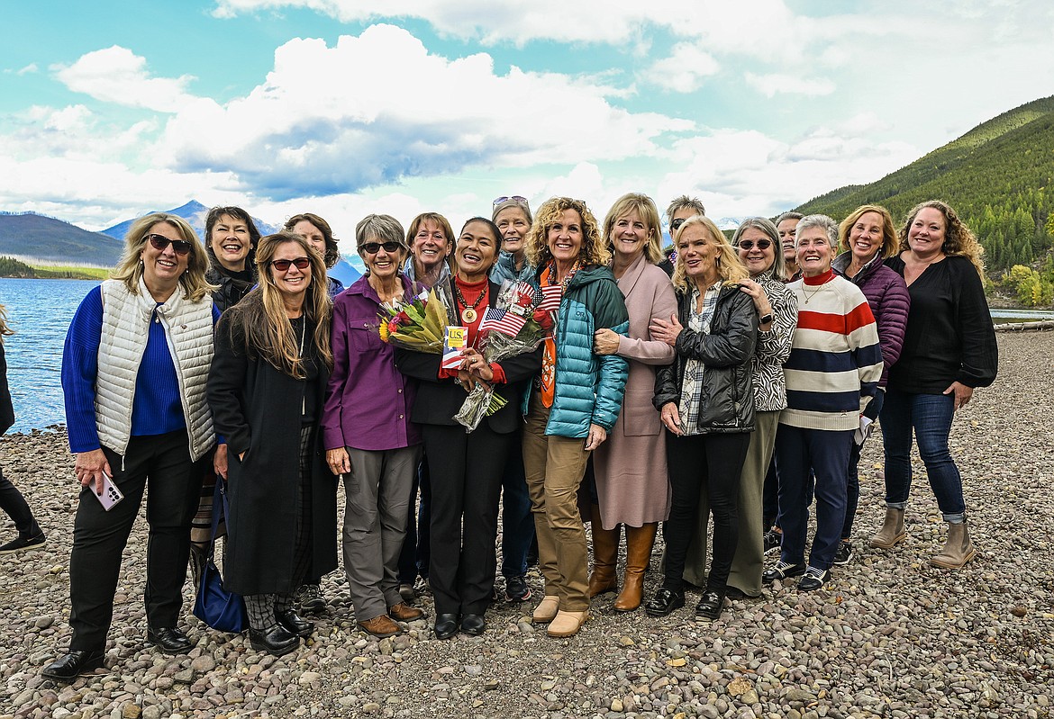 Saovanee Cunningham, center, with flags and a host of friends pose for pictures at Lake McDonald in Glacier National Park Friday after she became an U.S. Citizen. A naturalization ceremony was held in the park. (Chris Peterson photo)