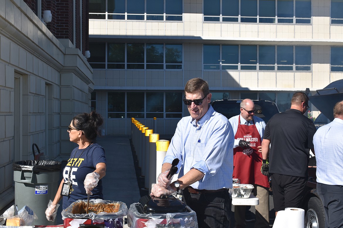 Grant County Commissioner Danny Stone, right, mans a warmer filled with burger patties and hot dogs during Wednesday’s appreciation luncheon for county staff while County Auditor Michele Jaderlund visits with staff and serves baked beans.