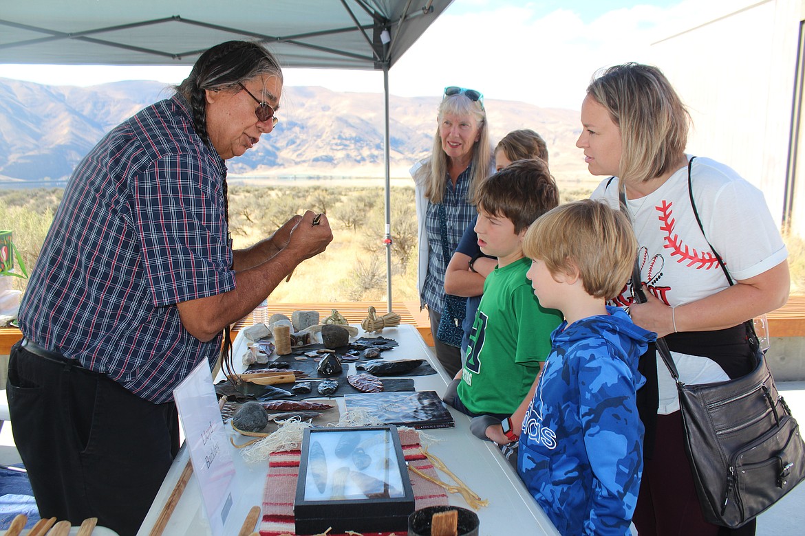 Lloyd Barkley, left, shows children how a projectile point is added to a spear or arrow shaft.