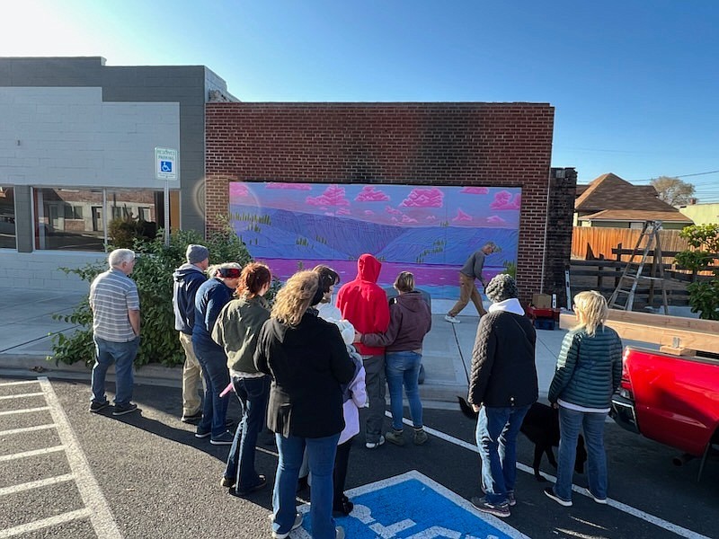 Soap Lake community members gather in front of the mural in downtown Soap Lake painted by local artist Emma Buchanan, which was installed Saturday morning.