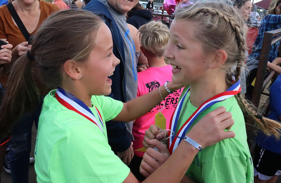 Fifth-graders Summer Dance, left, and Charlotte Carr celebrate after finishing their race in the Coeur d'Alene School District's annual elementary school cross country meet at the Kootenai County Fairgrounds on Thursday. Carr won and Dance was second.