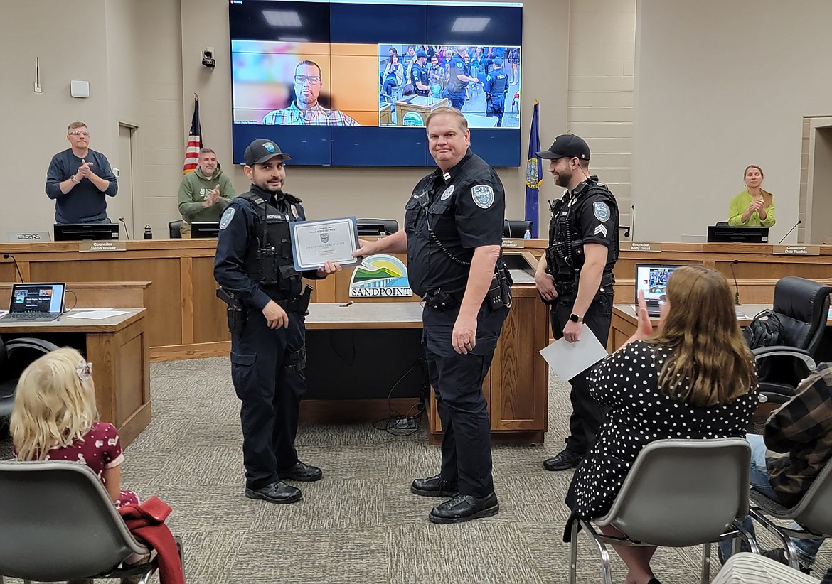 Sandpoint Police Officer David Hopman, left, is presented a Life Saving Award at Wednesday's Sandpoint City Council meeting. Presenting the award are Sandpoint Police Capt. Rick Bailey, center, and Sgt. Skylar Ziegler, right.