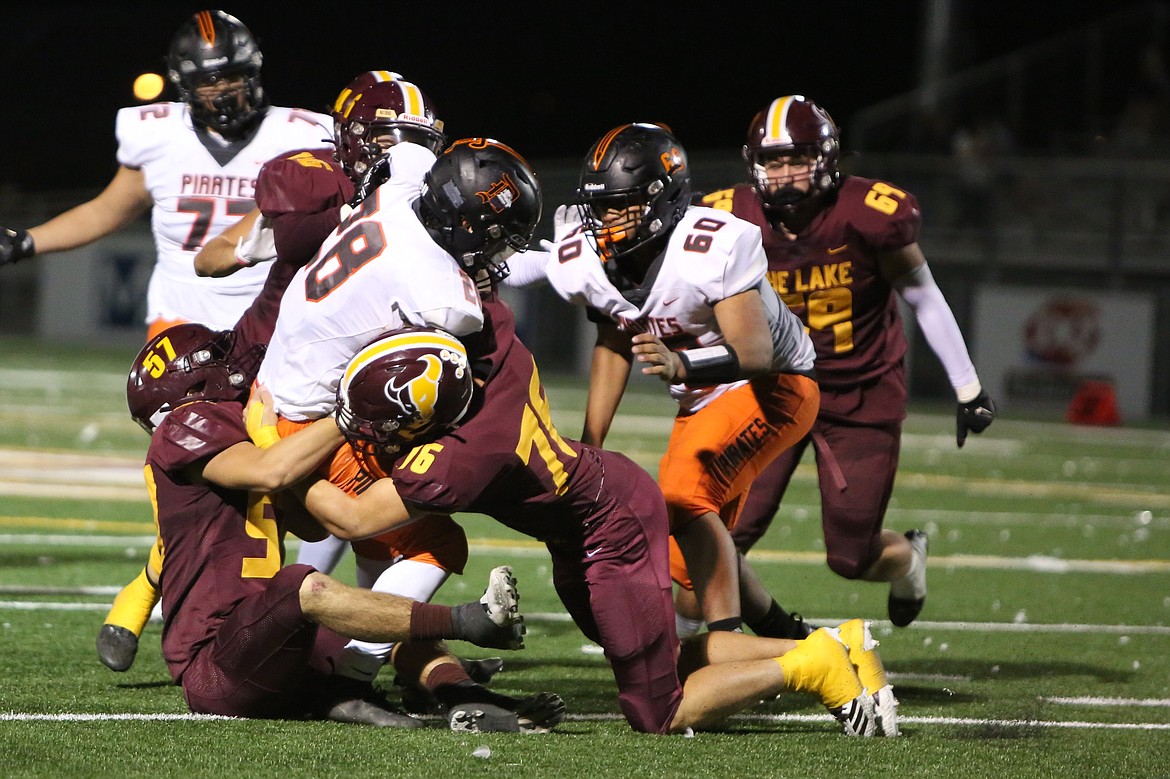 Moses Lake junior Hunter Blackman (76), junior Cylar Meseberg (57) and sophomore Carter Anderson (6) combine for a tackle in the second half against Davis.