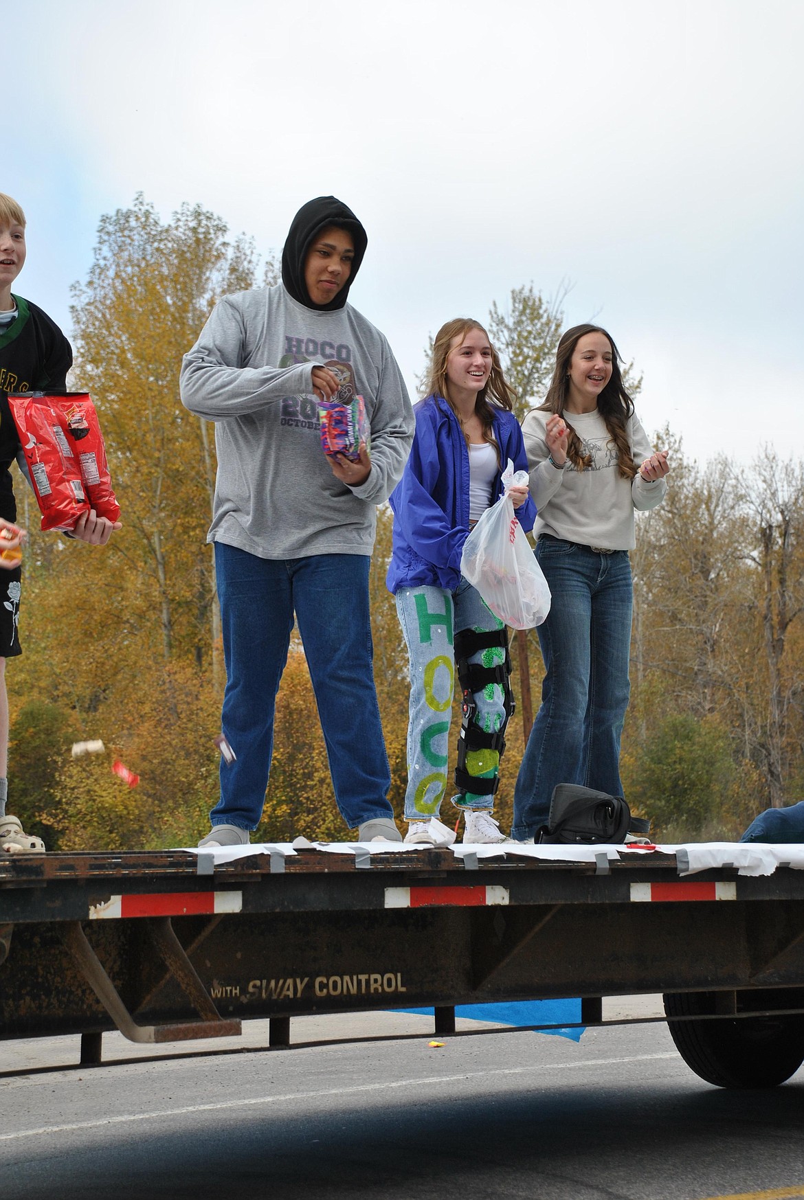 Sophomores DJ McCoy, Jamie Kearby and Emma Gillette toss candy from their homecoming float which featured an ACME anvil smooshing the Coyote. (Mineral Independent/Amy Quinlivan)