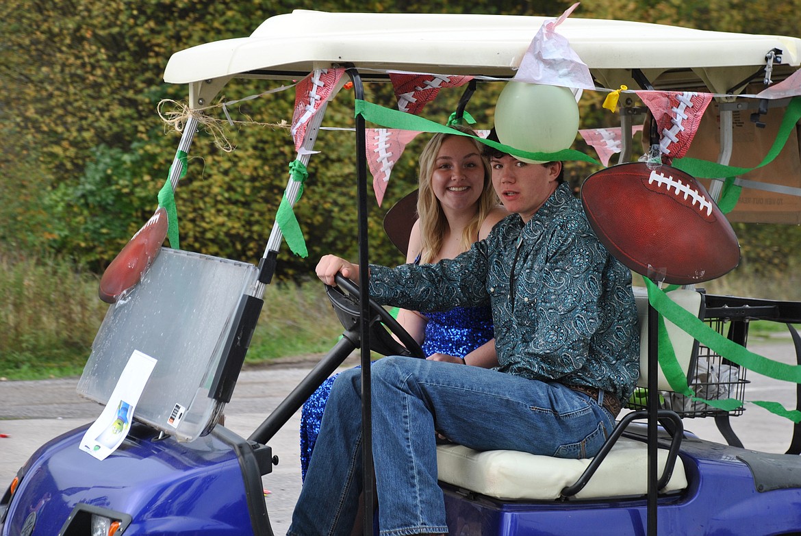 Senior royalty, James Roe and Brooke Filek cruise by in a decked-out golf cart. (Mineral Independent/Amy Quinlivan)