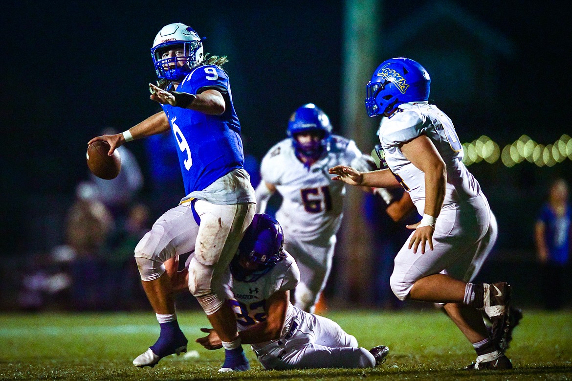 Columbia Falls quarterback Cody Schweikert (9) throws under pressure from Libby's Joel Goodman (32) in the second quarter at Satterthwaite Field on Friday, Oct. 6. (Casey Kreider/Daily Inter Lake)