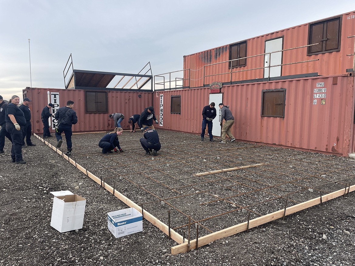 Crew members work on the addition of a concrete drill pad at the Coeur d'Alene Airport. The pad will significantly enhance the training experience for Northern Lakes Fire personnel, providing a clean, flat surface for staging equipment and performing essential functional drills.