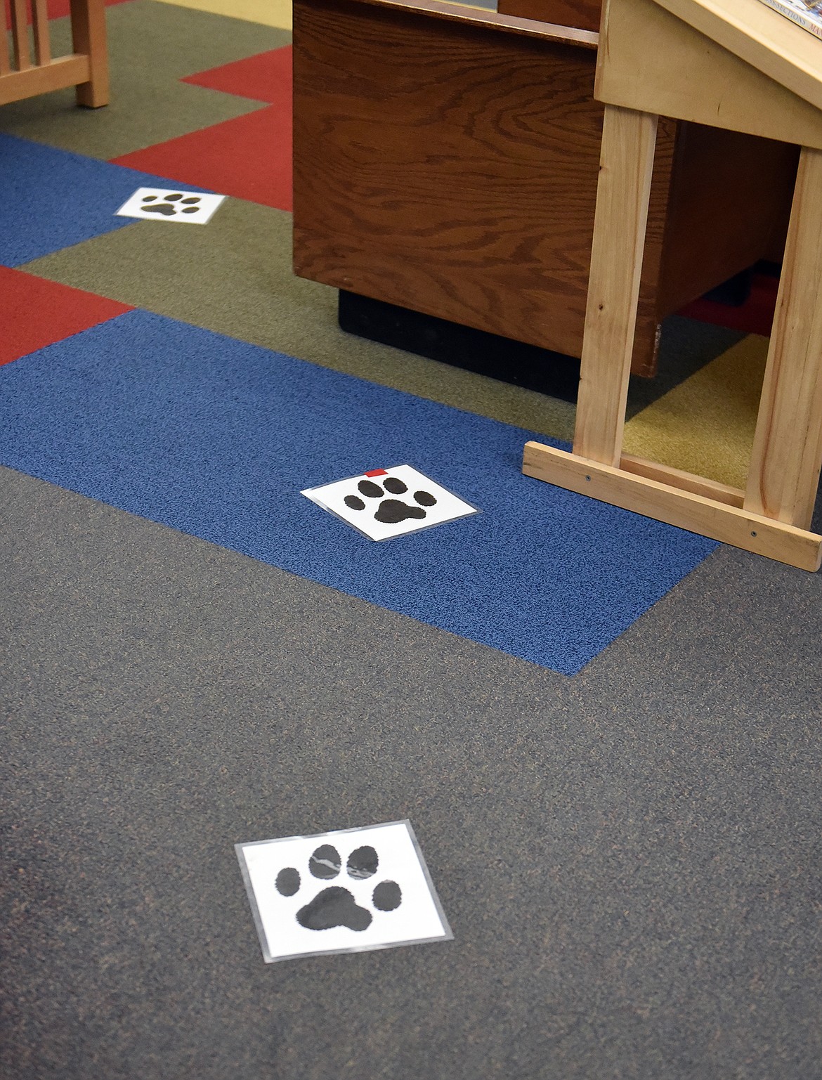 Paw prints on the floor of the library direct young readers to the R.E.A.D. program's corner. (Julie Engler/Whitefish Pilot)