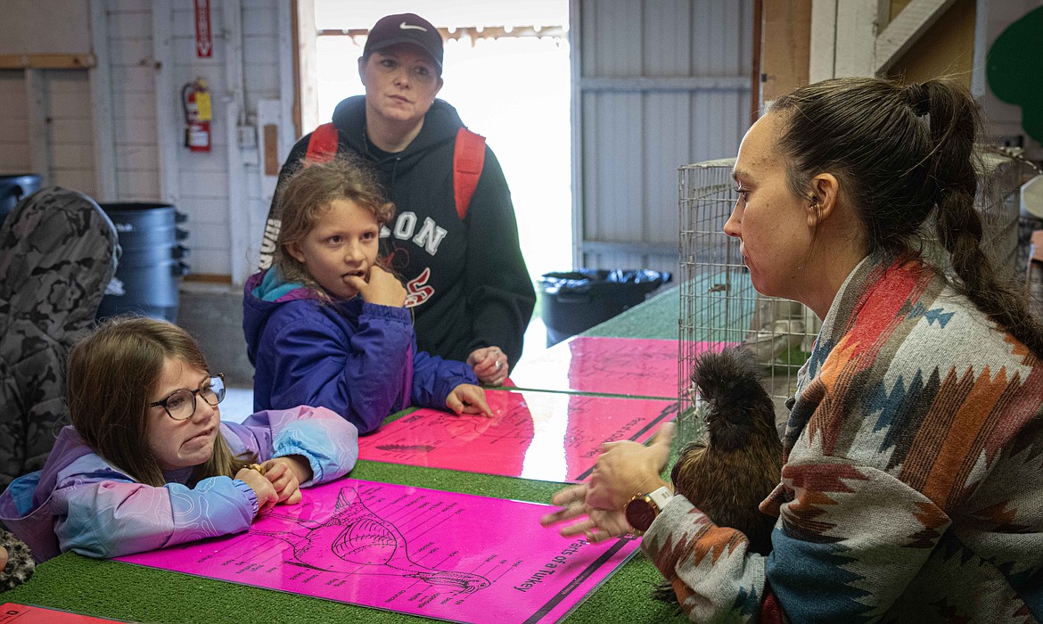 Whitney Spurr talks with students Annabelle Torrey and Caydence Etienne at the Eggciting Chickens booth at Ag Days. (Tracy Scott/Valley Press)