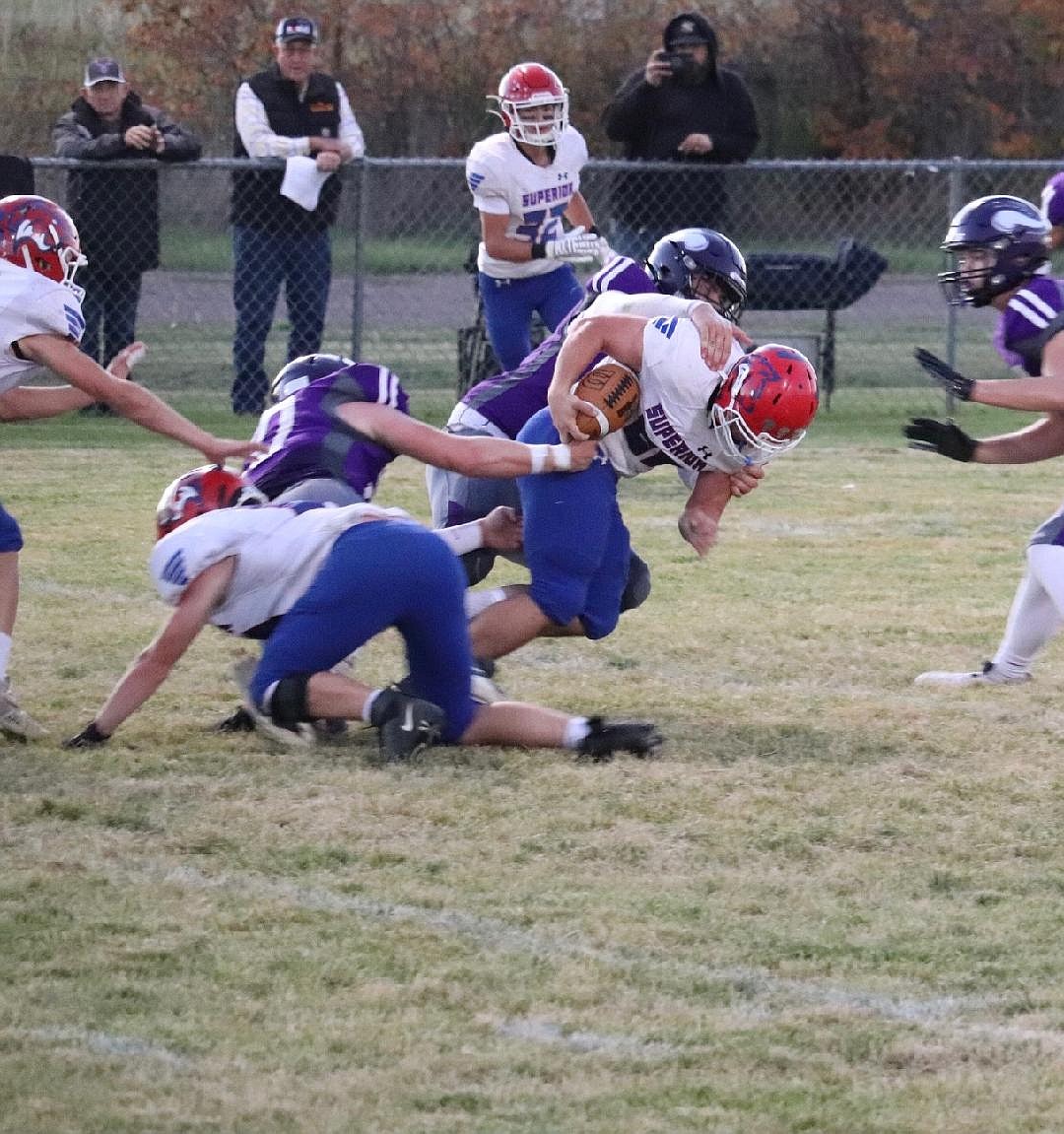 Superior running back Chase Woods (with ball)  runs into a horde of Charlo tacklers during their game this past Friday night in Charlo.  (Photo by Kami Milender)