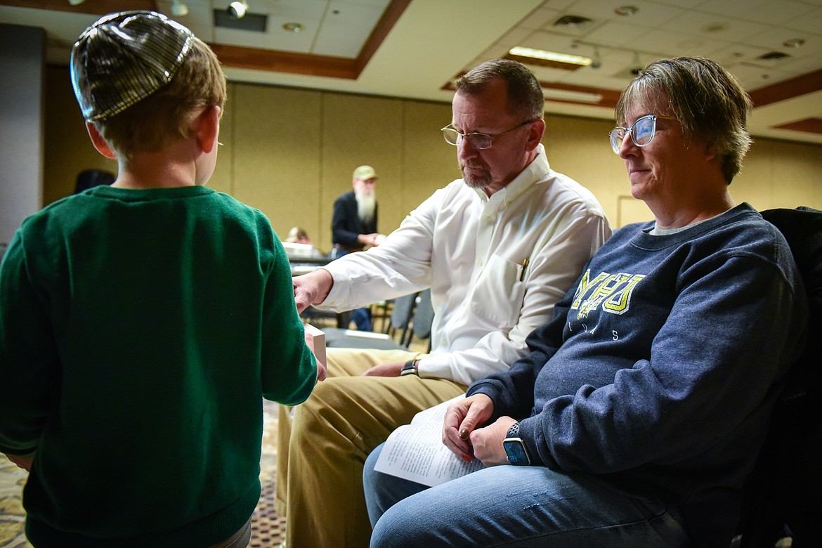 Kalispell Mayor Mark Johnson makes a donation in a charity box passed around at a United for Israel gathering at the Red Lion Hotel in Kalispell on Tuesday, Oct. 10. Coins were handed out to attendees so that everyone could participate in the act of charity. (Casey Kreider/Daily Inter Lake)