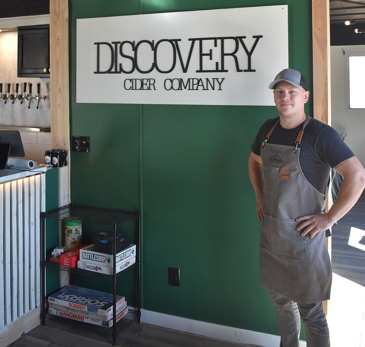 Brennan James stands in front of the cidery’s business sign inside the cidery lounge. The watering hole will have a selection of board games for patrons to enjoy as well as a variety of outdoor games in the business’s yard.