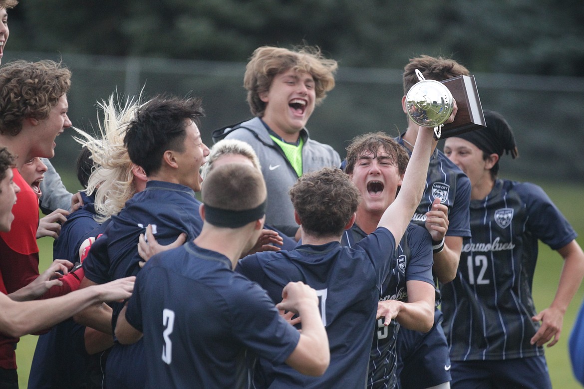 JASON ELLIOTT/Press
Lake City senior midfielder Connor Jump (7) hoists the 5A Region 1 boys soccer championship trophy as his teammates celebrate following the Timberwolves 3-1 win over the Coeur d'Alene Vikings on Wednesday at the Irma Anderl Soccer Complex.