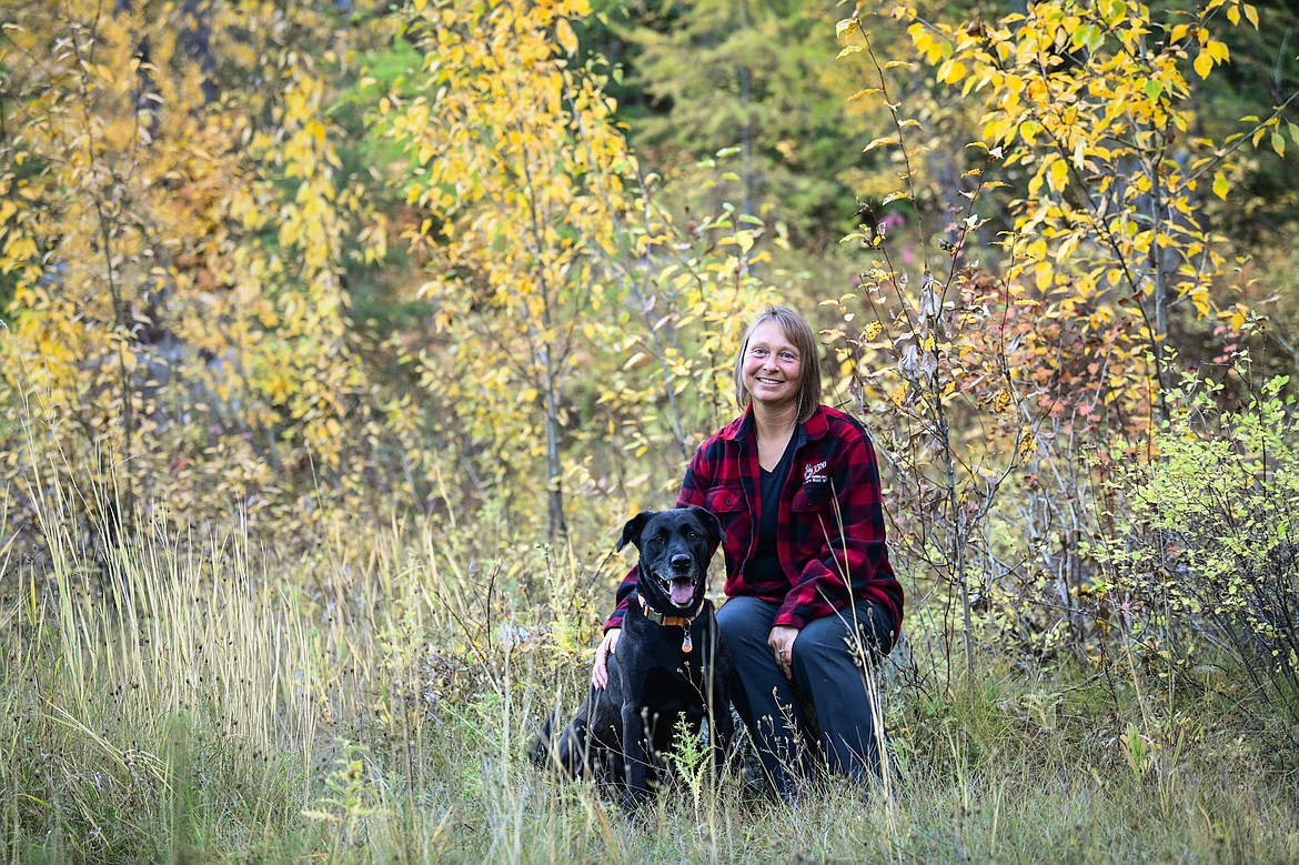 Roberta Schuppel with her dog Moose along the trail on her property where they walked every day during treatment and recovery from breast cancer on Monday, Oct. 9. (Casey Kreider/Daily Inter Lake)