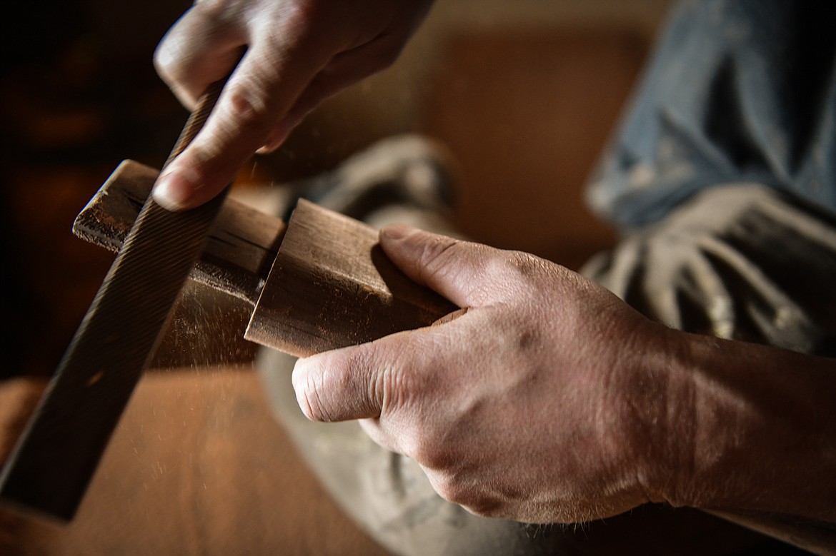 Steve Henneford sands a stretcher for one of his cowboy rockers in the sanding room of his workshop at Henneford Fine Furniture on Tuesday, Oct. 10. (Casey Kreider/Daily Inter Lake)