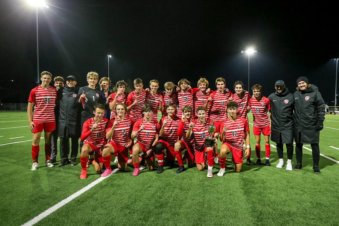 The Sandpoint boys soccer team and coaching staff pose for a photo with their district championship trophy after defeating Moscow, 3-0 at War Memorial Field on Thursday.