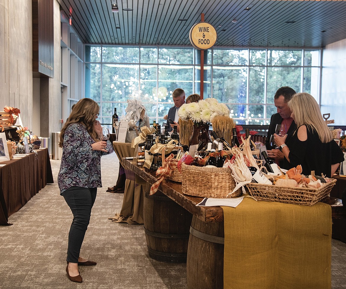 Attendees look at auction items during the Flathead Valley Community College’s Festival of Flavors Grand Wine Tasting event. (Photo courtesy of FVC