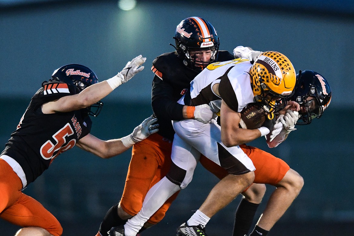 Flathead defenders Easton Capser (58), Stephen Riley (7) and Noah Sonju (8) bring down Helena Capital running back Cole Graham (25) in the first quarter at Legends Stadium on Friday, Oct. 13. (Casey Kreider/Daily Inter Lake)