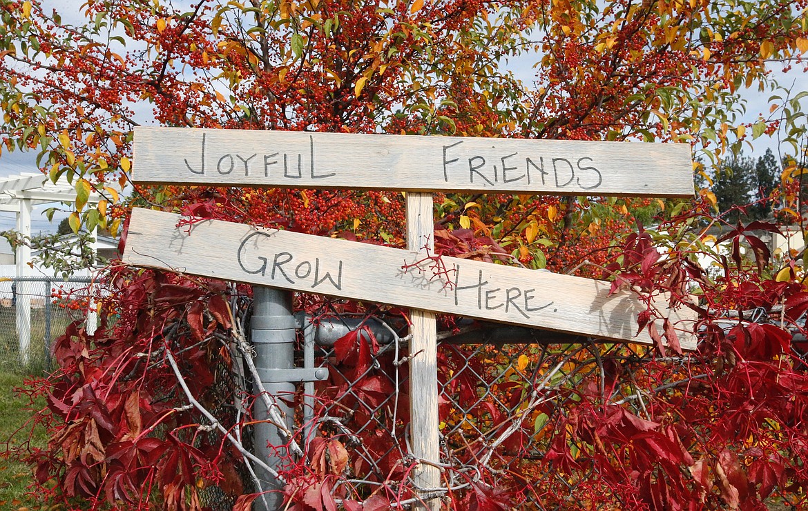 A sign welcomes all to the community garden.