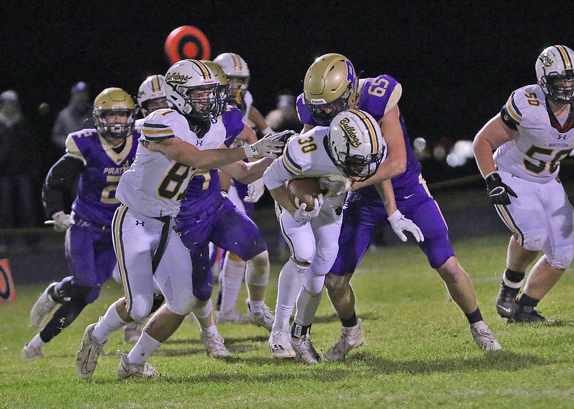 Polson Pirate Austin Oberwegner, who won All-State honors, tackles Whitefish runningback. (Bob Gunderson photo)