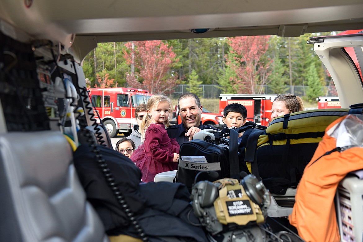 Whitefish firefighter Dave Mangold, with his granddaughter Maeve and other family members, check out the Alert helicopter at the open house last weekend. (Julie Engler/Whitefish Pilot)