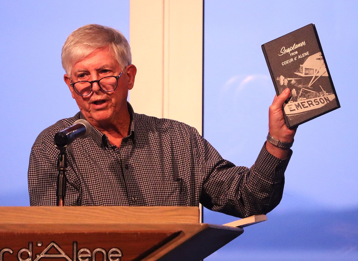 Sandy Emerson displays a book as he speaks during "Idaho Listens" at the Hagadone Event Center on Monday night.