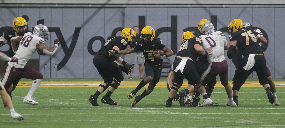 MARK NELKE/Press
Idaho quarterback Gevani McCoy (4) scrambles against Montana on Saturday night at the Kibbie Dome in Moscow.