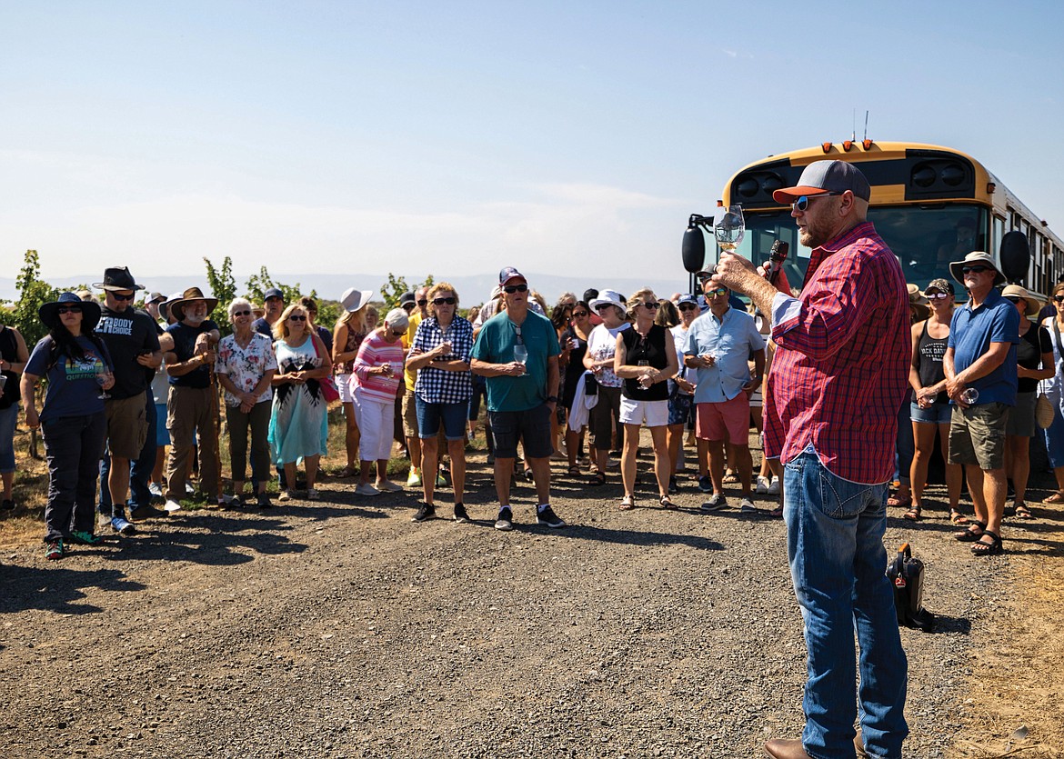 Josh Lawrence, right, speaks to visitors at Gård Vintners’ vineyard tour in August.