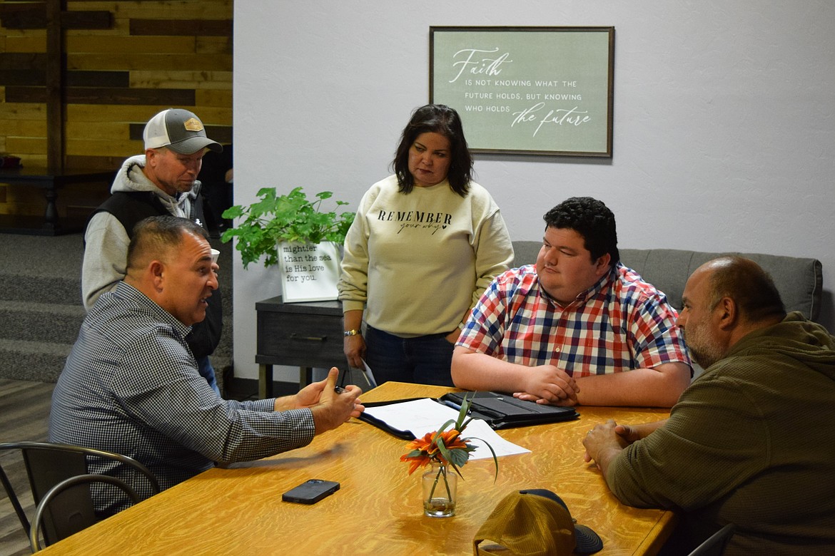 Othello School District Superintendent Pete Perez, seated left, discusses the Othello School Board with school board candidate Chris Baginksi, standing left, Lighthouse Café Program Director Angela Kudsk, candidate Aaron Gerber, seated middle, and candidate Isauro Pruneda Jr., seated right, during Monday’s meet-and-greet event at Lighthouse.