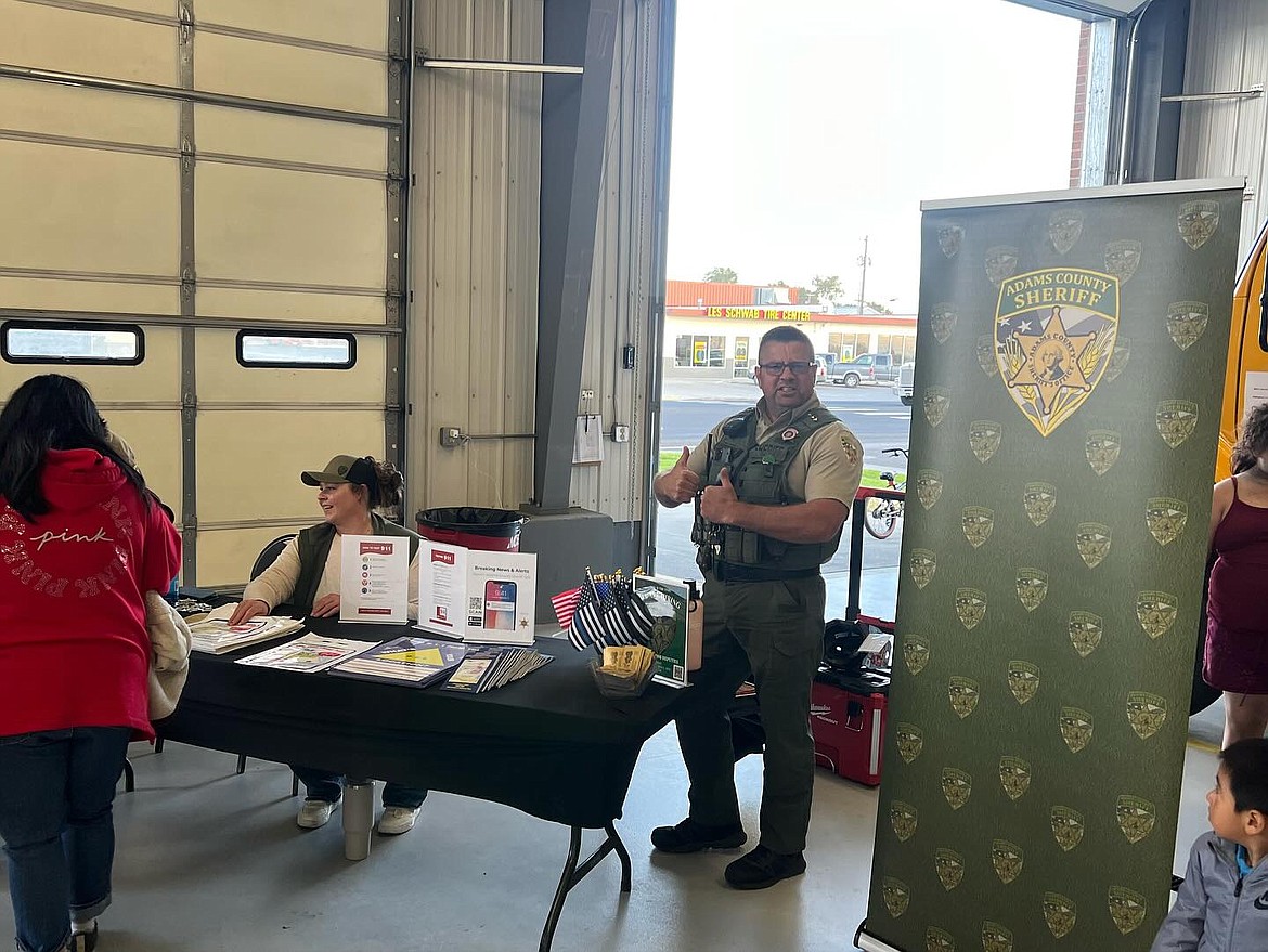 Adams County Sheriff Dale Wagner, right, stands beside an informational booth for the Sheriff’s Department at the Adams County Fire District 5 annual open house Oct. 12 in Othello.