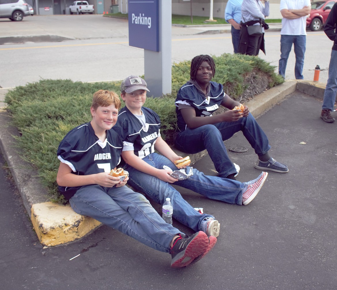 Middle School football players eat at the Homecoming Tailgate.