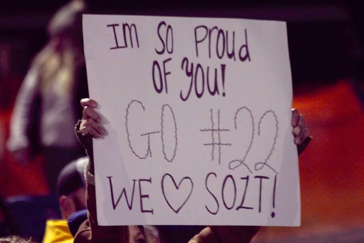 Parents holds sign during Homecoming football game.